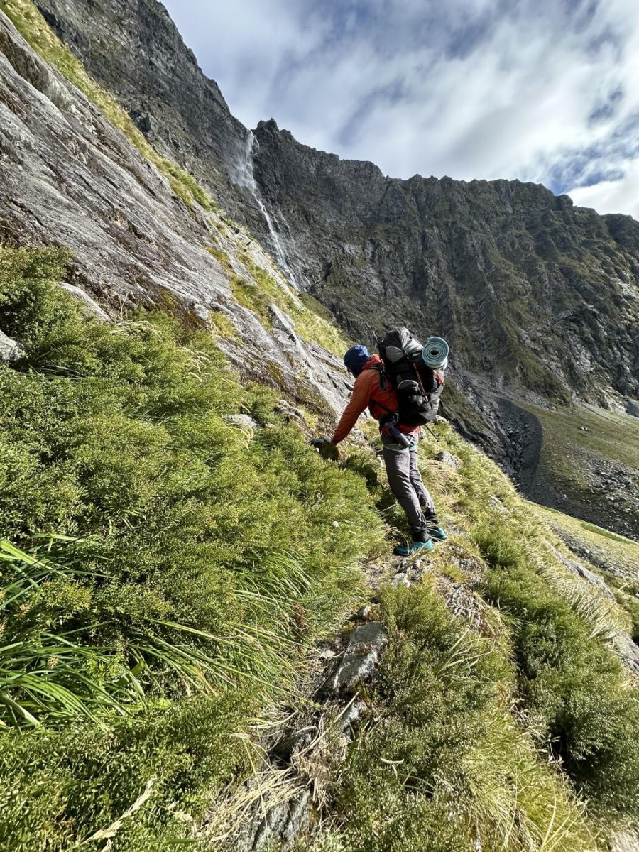 Backpacker climbing mountain trail