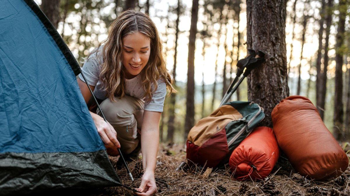 Female backpacker setting up camping gear