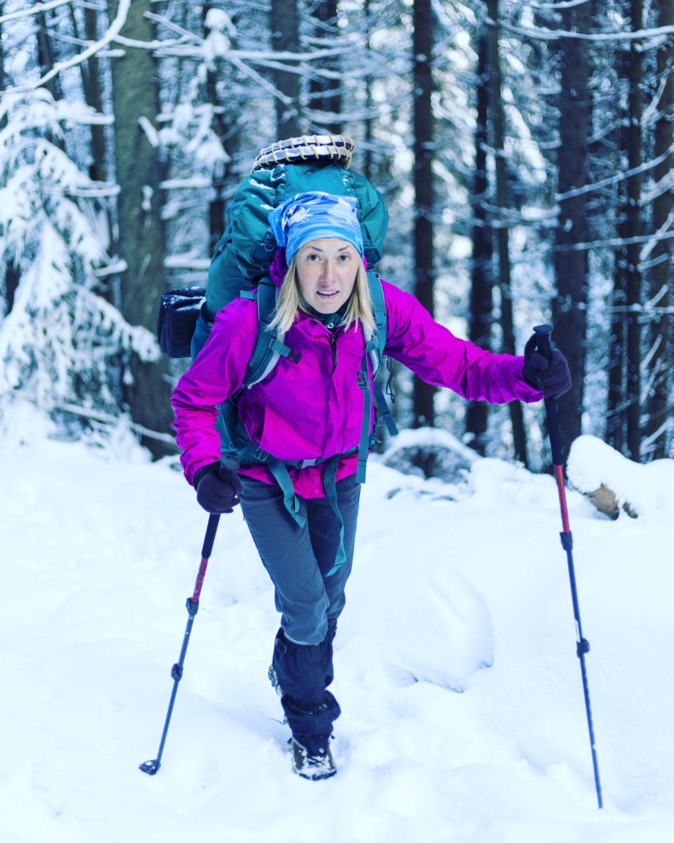 Woman hiking with winter outdoor gear