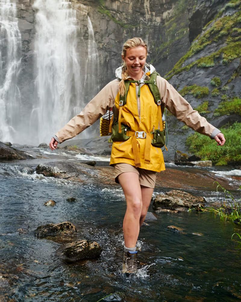 Hiker crossing stream waterfall