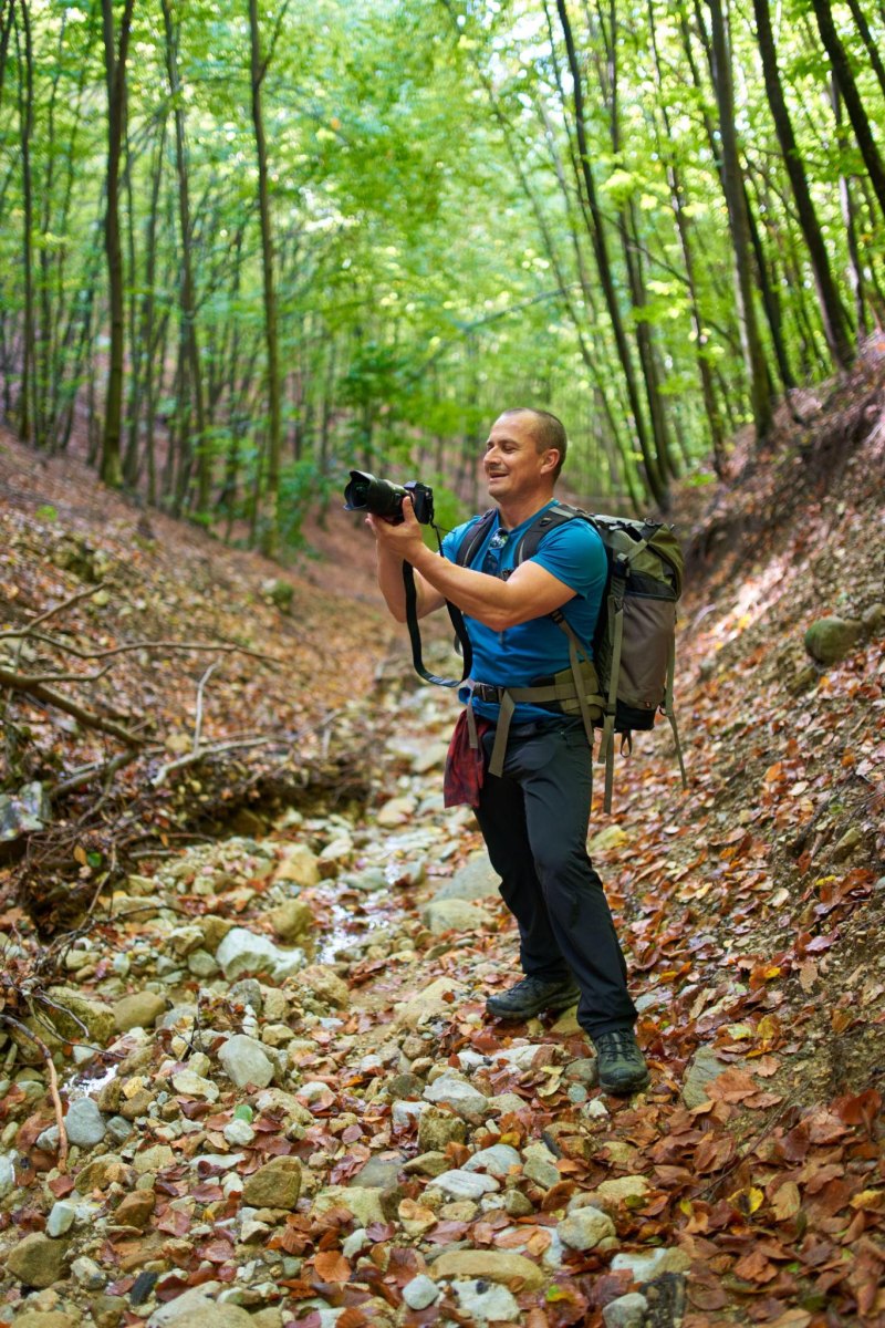 Hiker photographing autumn forest