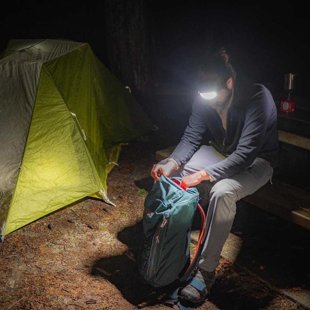 Headlamp glowing at campsite