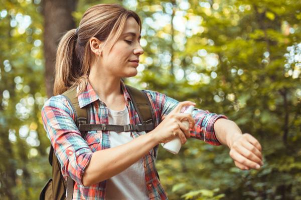 Woman hiker applying insect protection