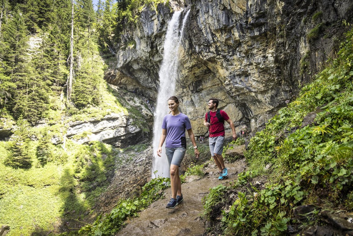 Couple exploring a waterfall cave hiking destination