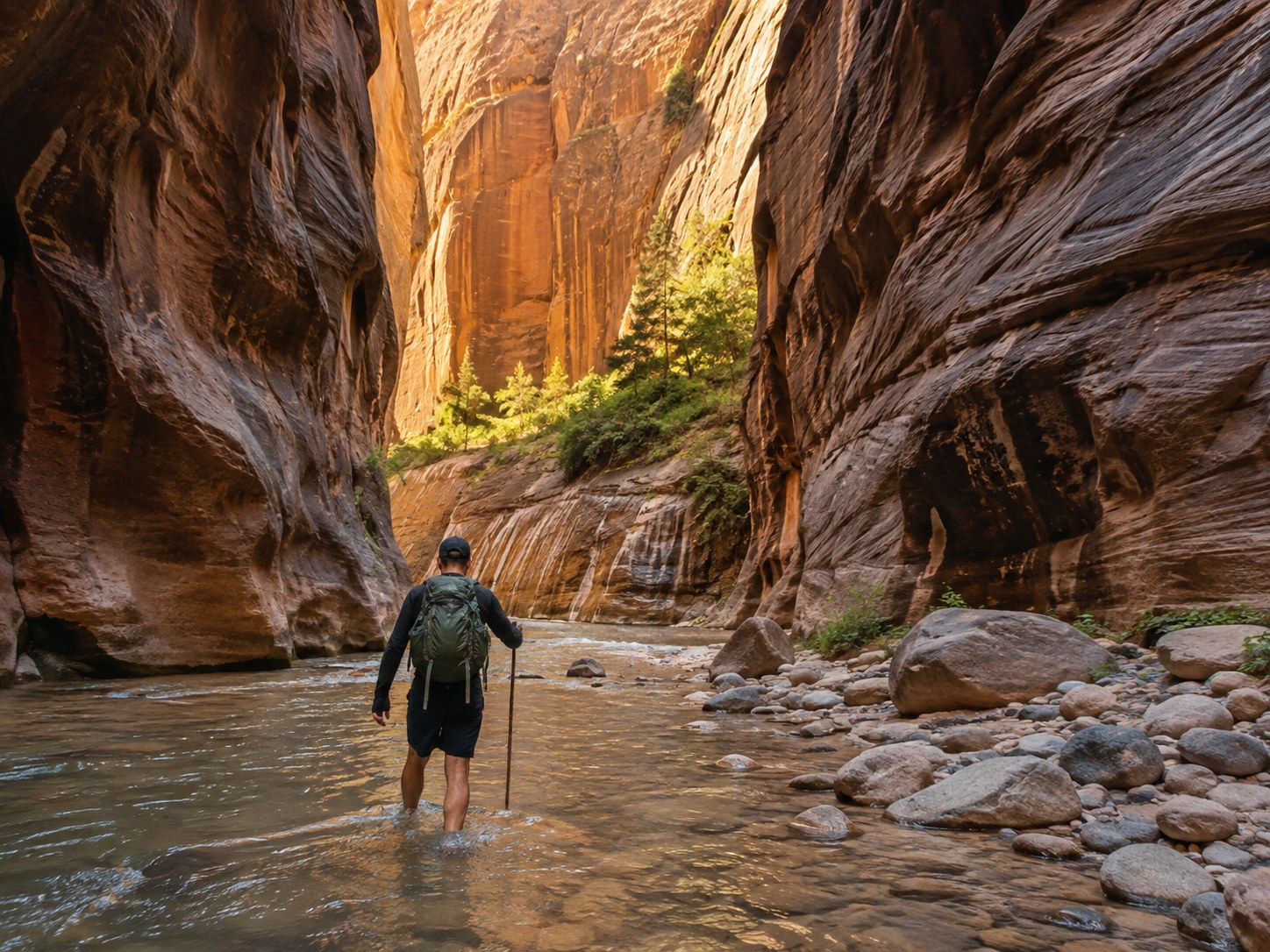 A hiker wading through the Virgin River in Zion National Park's Narrows trail, Utah