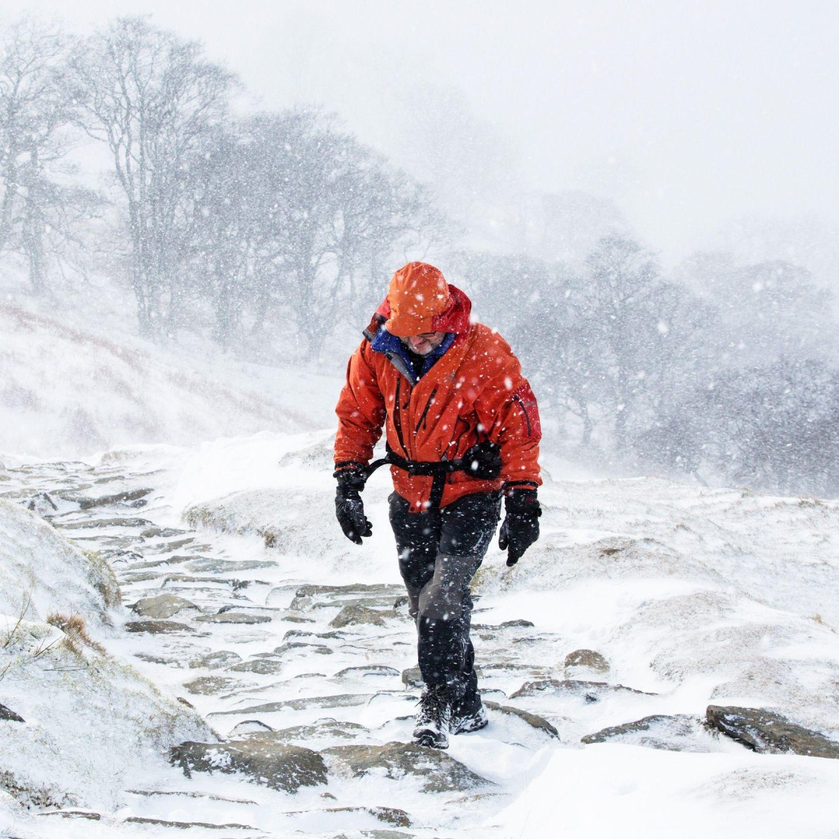 Snowy mountain hiker wearing waterproof shell