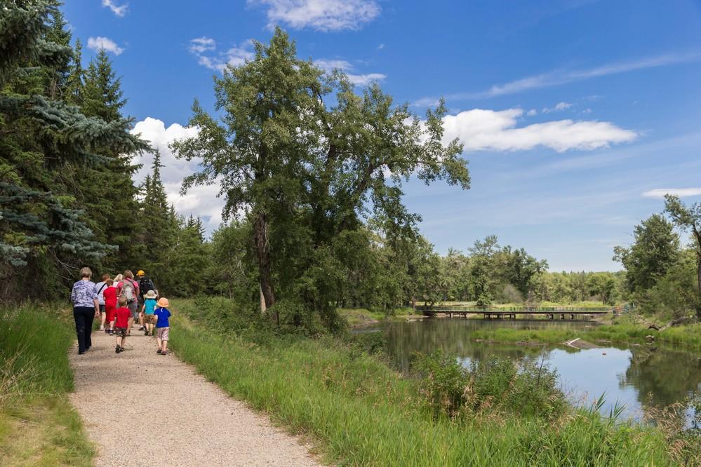 Family hiking beside a flowing river trail