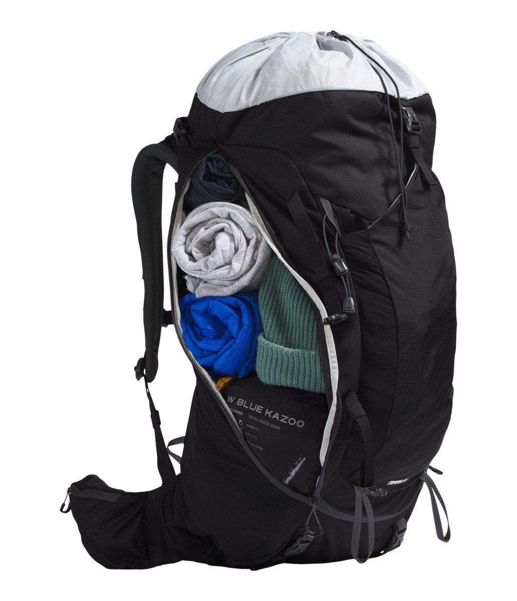 Black backpack packed with rolled clothing for backpacking