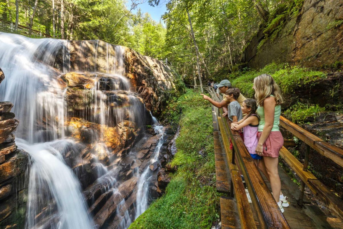 Parents watching children near waterfall trail