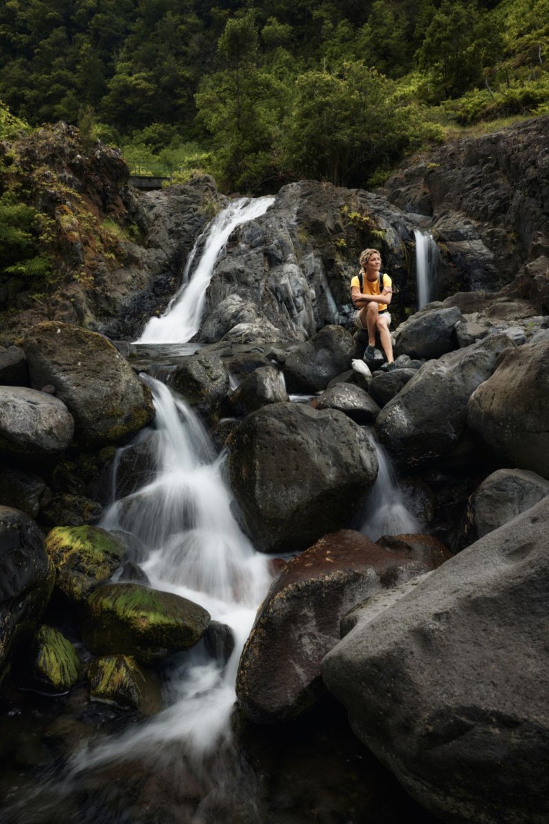 Hiker sitting beside waterfall