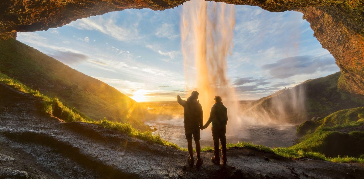 Couple exploring a waterfall cave hiking destination