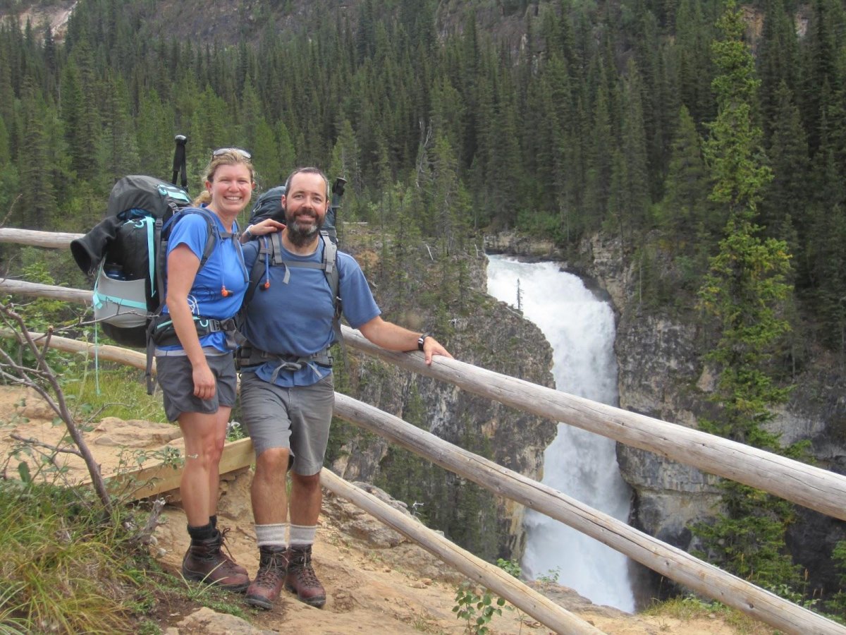 Couple exploring a waterfall cave hiking destination