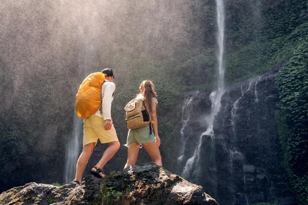 Couple exploring a waterfall cave hiking destination