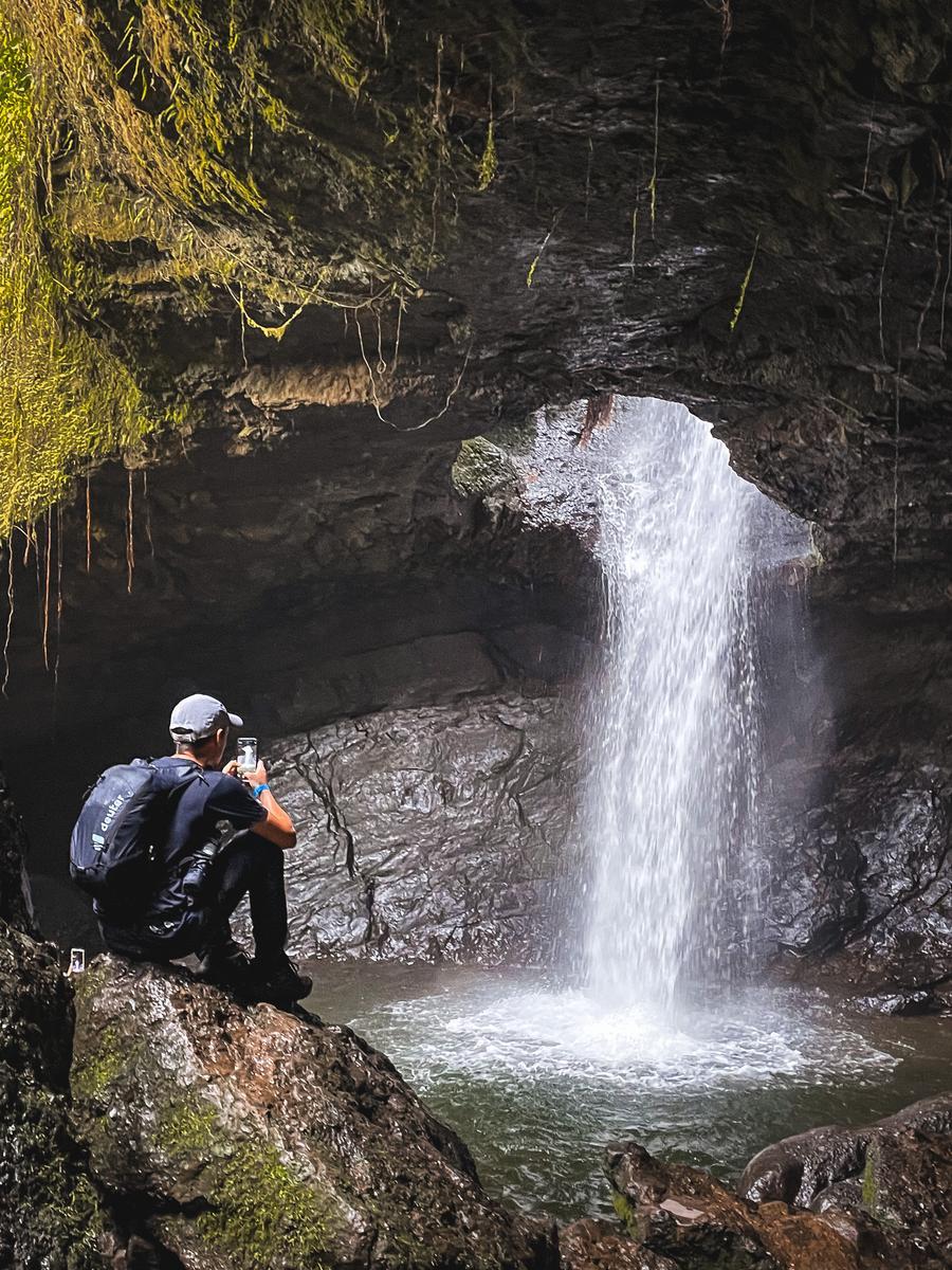 Couple exploring a waterfall cave hiking destination