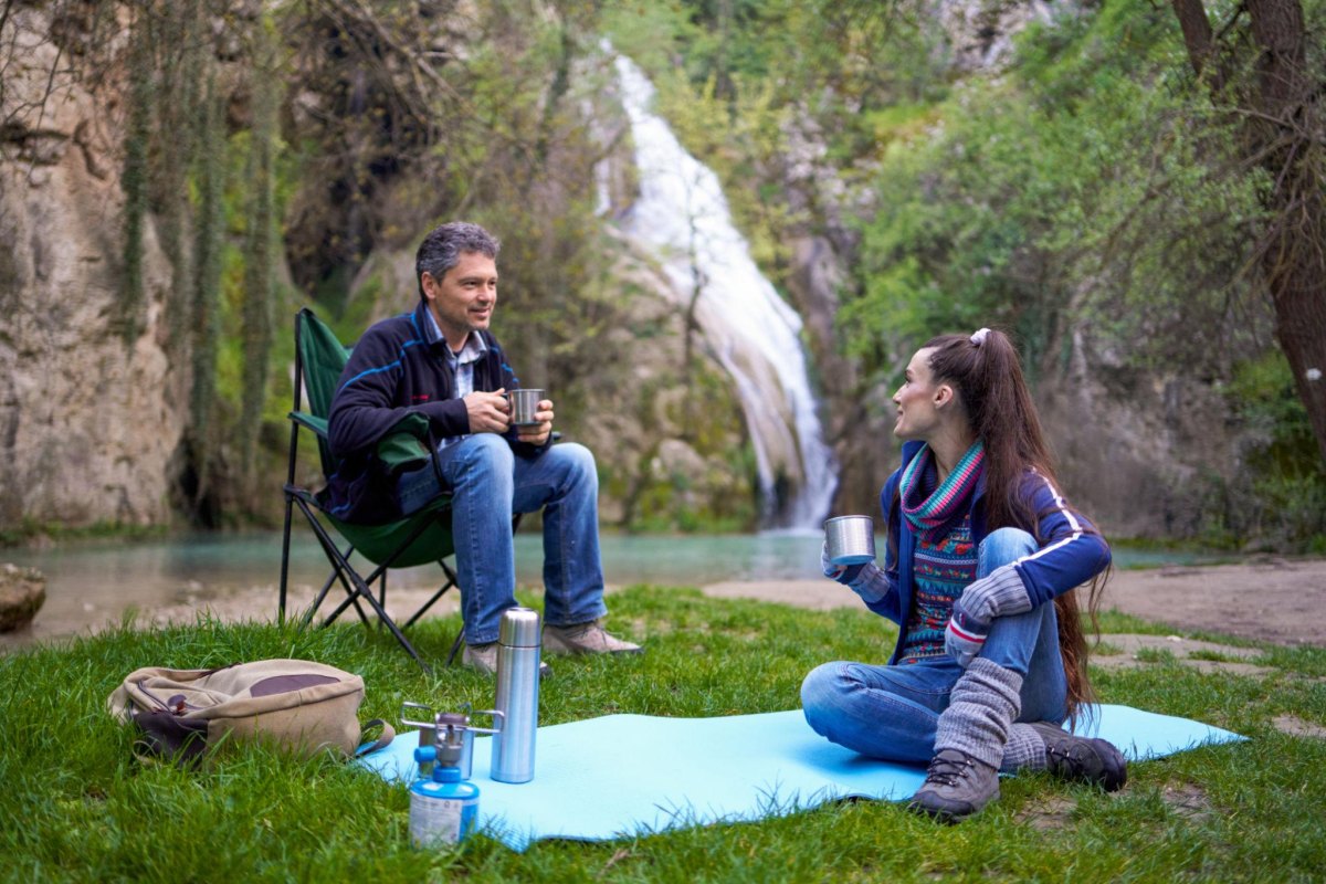 Couple exploring a waterfall cave hiking destination