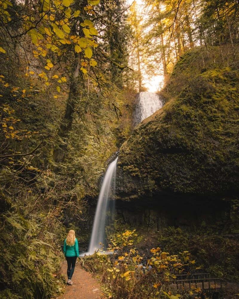Couple exploring a waterfall cave hiking destination