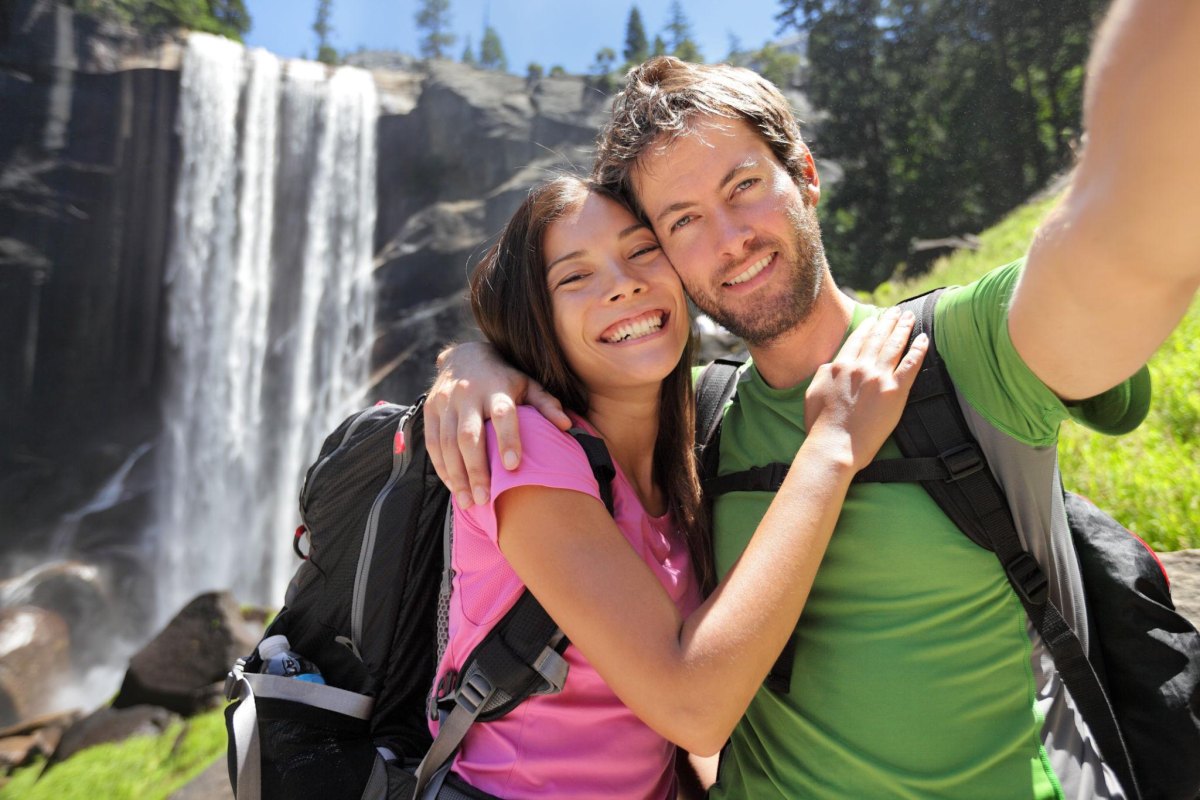 Couple exploring a waterfall cave hiking destination