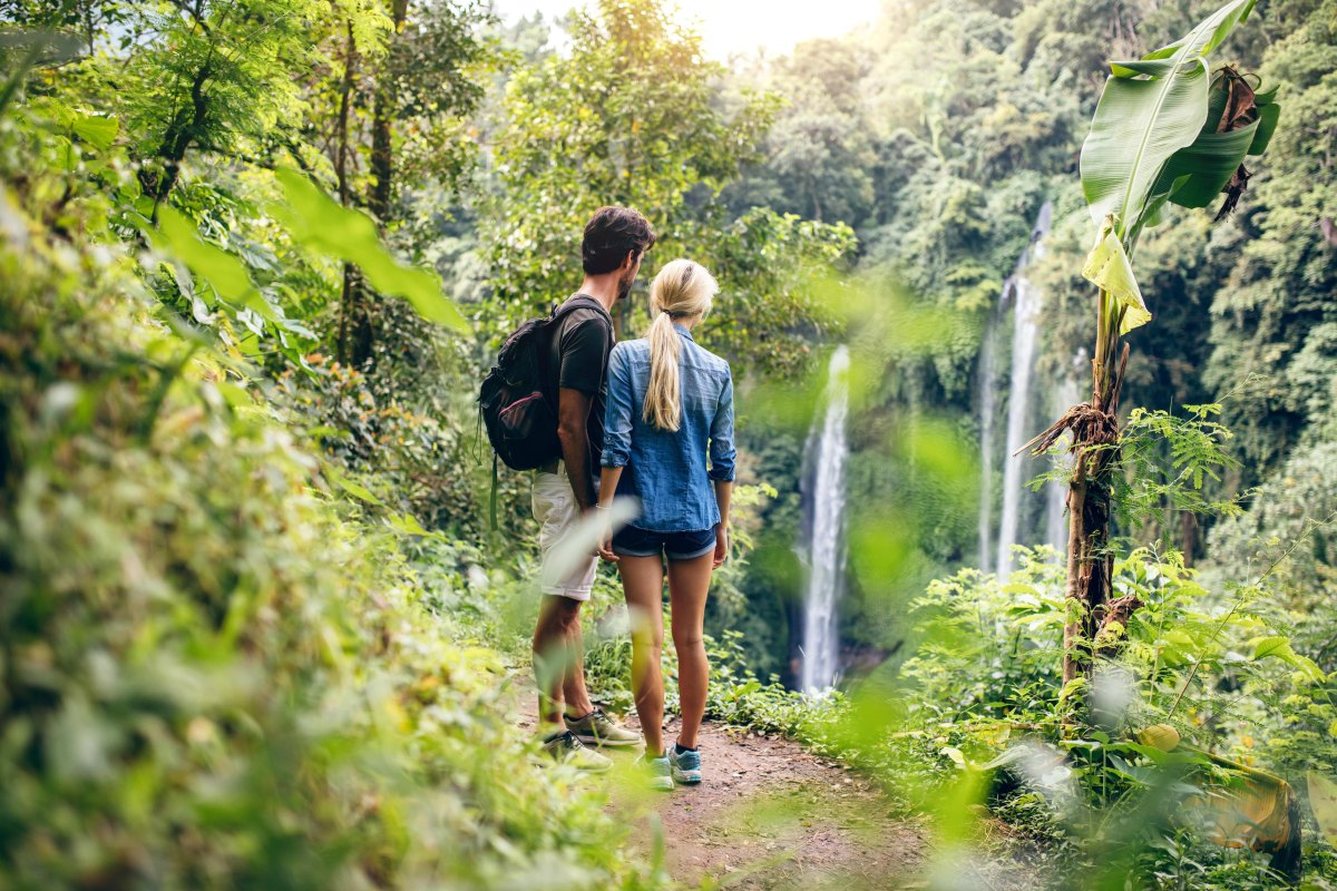 Couple exploring a waterfall cave hiking destination